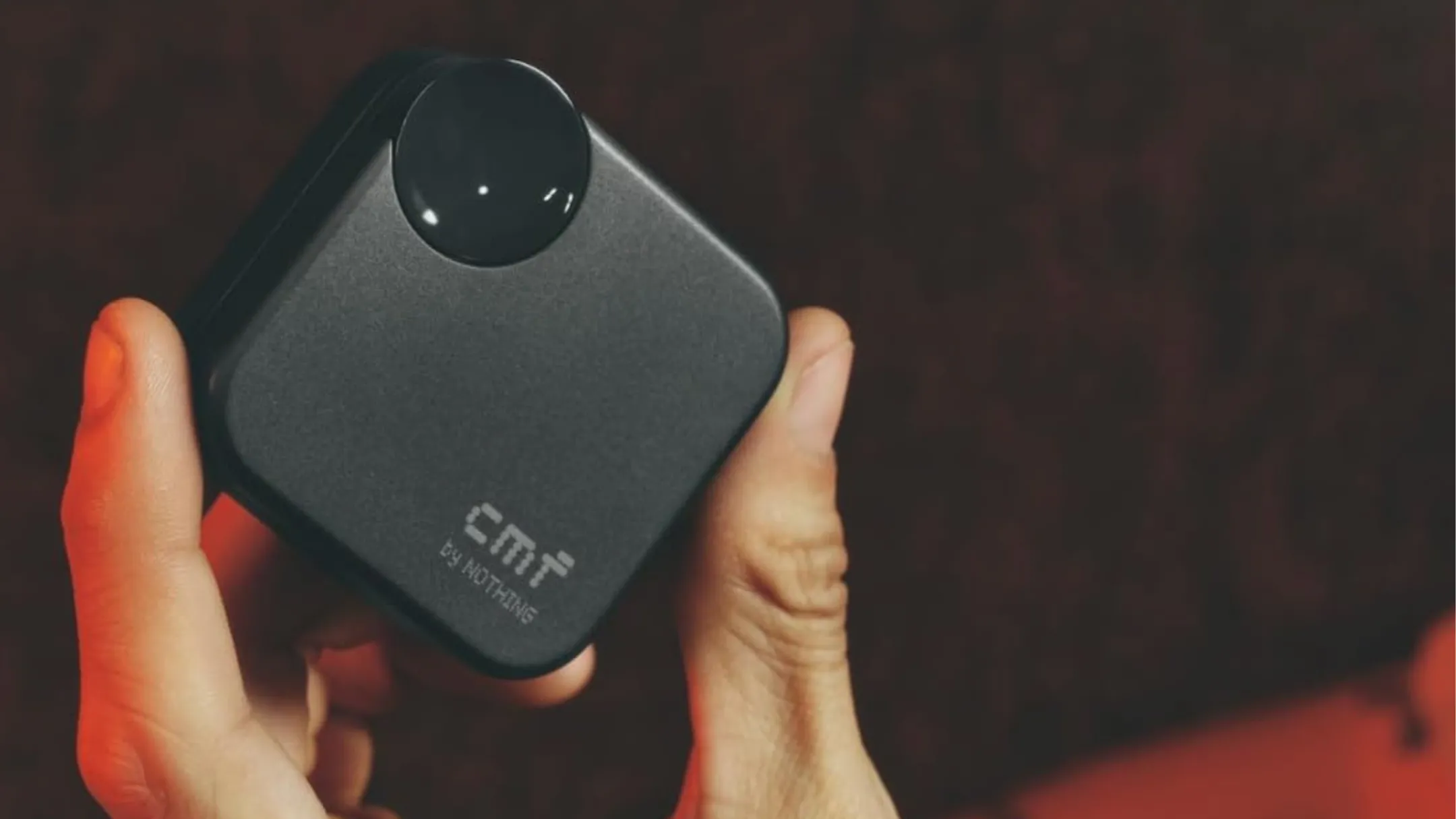 Người đang cầm tai nghe không dây CMF Buds 2a màu xám