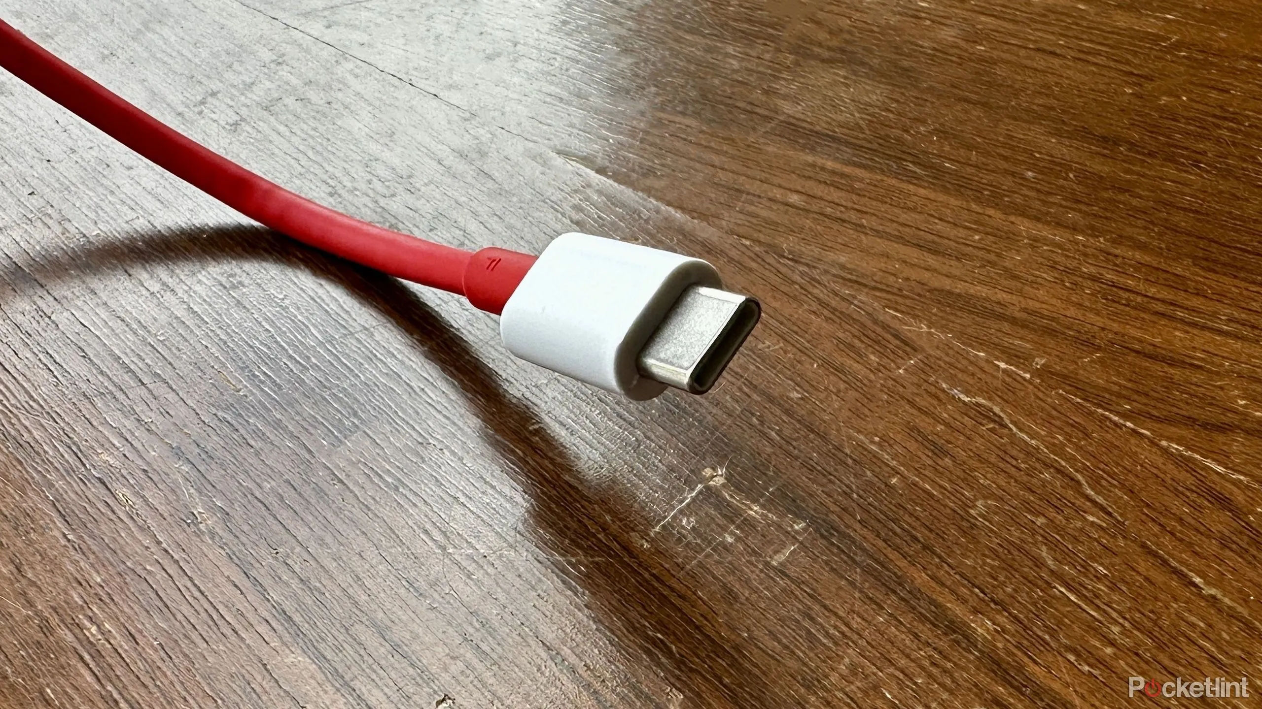 Sợi cáp USB-C màu đỏ đặt trên rương gỗ cũ