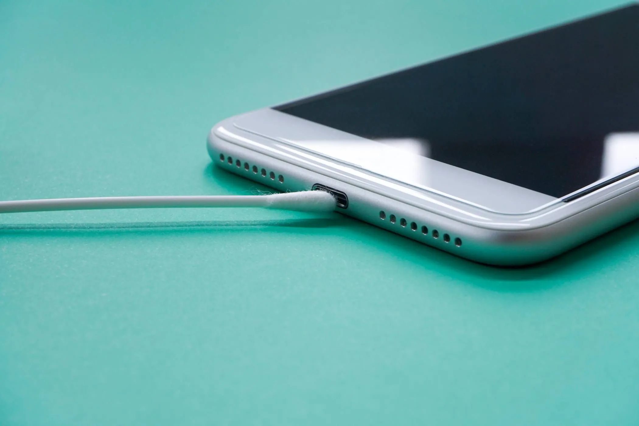 Tăm bông đang làm sạch cổng sạc USB-C của điện thoại Samsung để loại bỏ hơi ẩm.