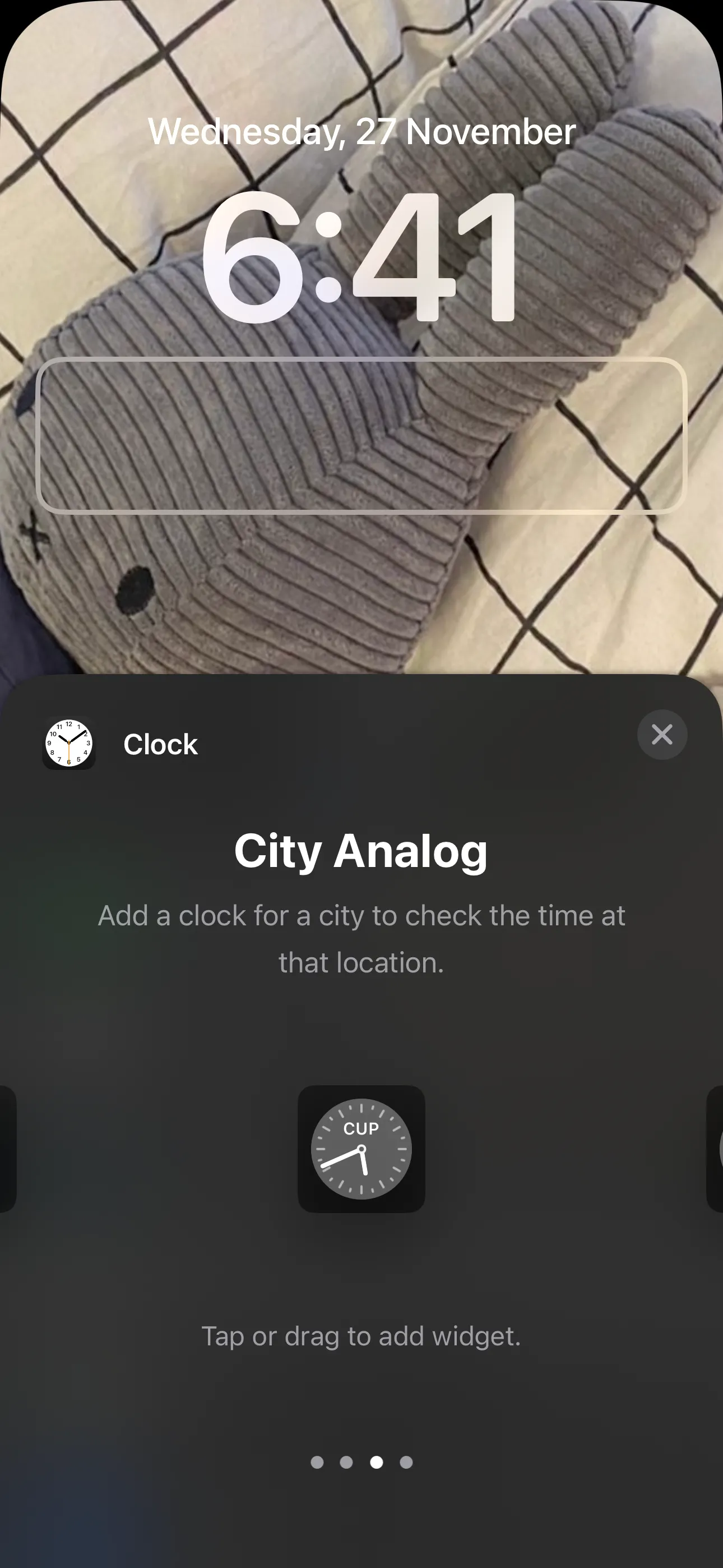 Widget đồng hồ kim loại hiển thị trên Màn hình khóa iPhone với nhiều múi giờ khác nhau