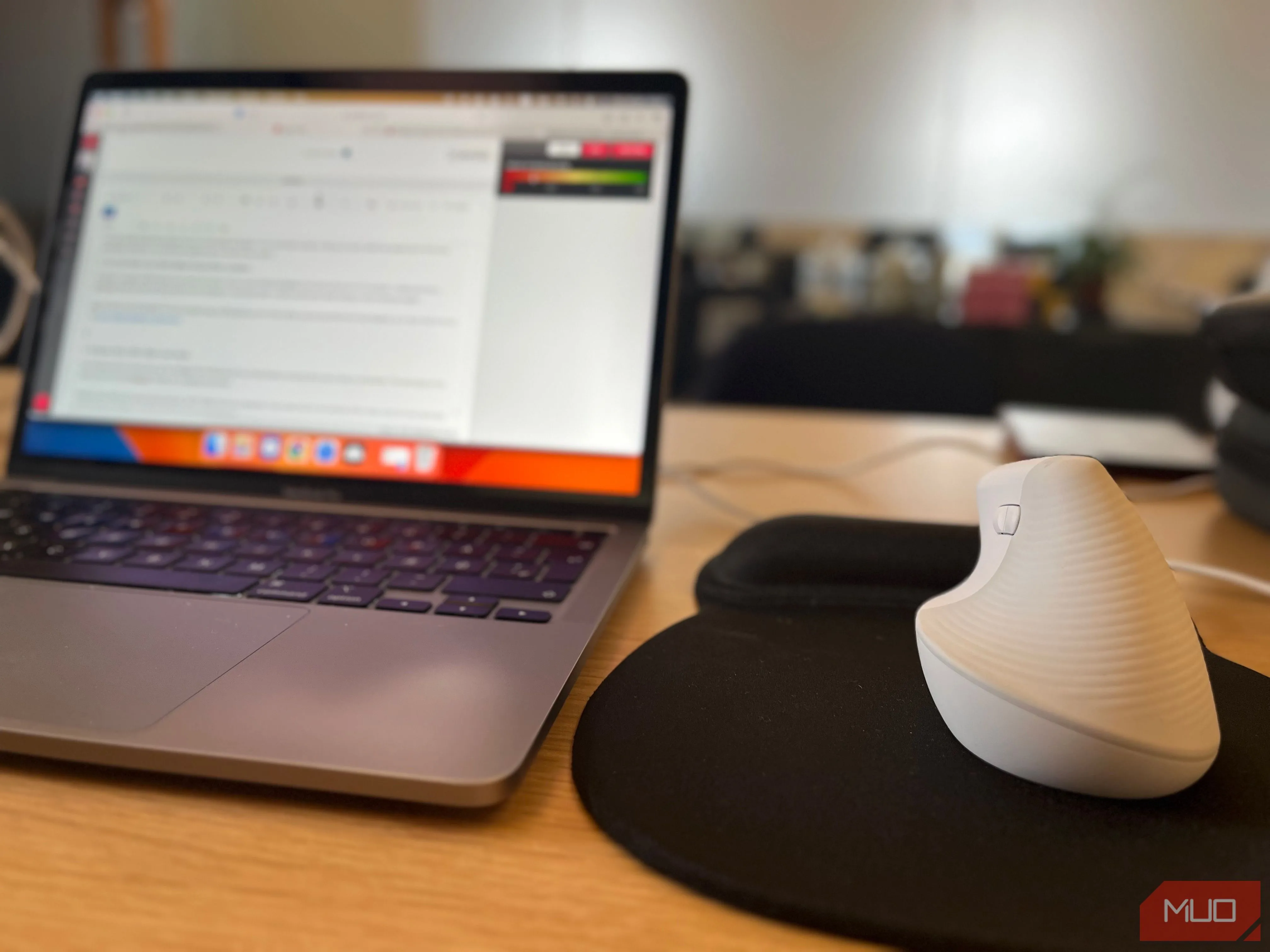 Chuột không dây và laptop trên bàn tại không gian làm việc chung, nhấn mạnh tính di động và linh hoạt