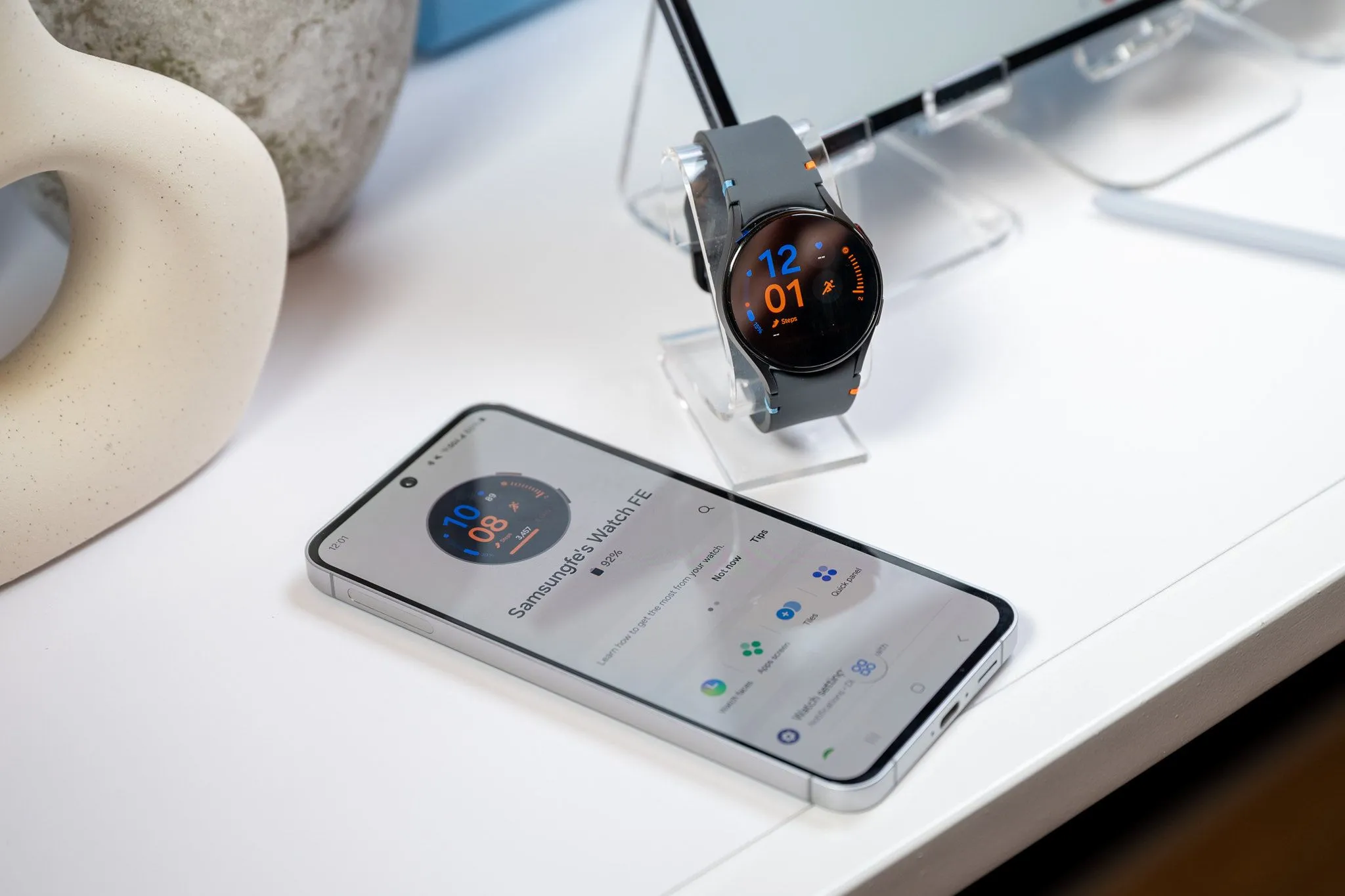 Điện thoại Samsung Galaxy S24 FE đang sạc pin cho Galaxy Watch LTE qua cổng USB-C.