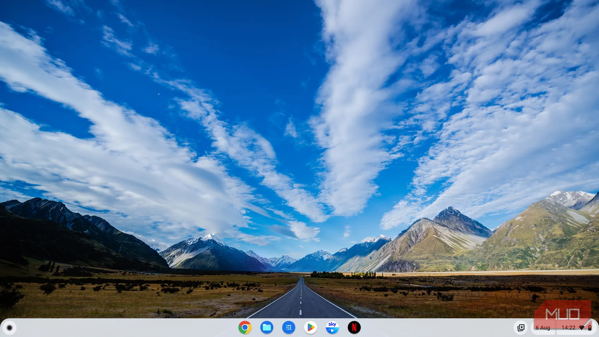 Giao diện màn hình chính của ChromeOS với hình nền phong cảnh và thanh dock ứng dụng tối giản