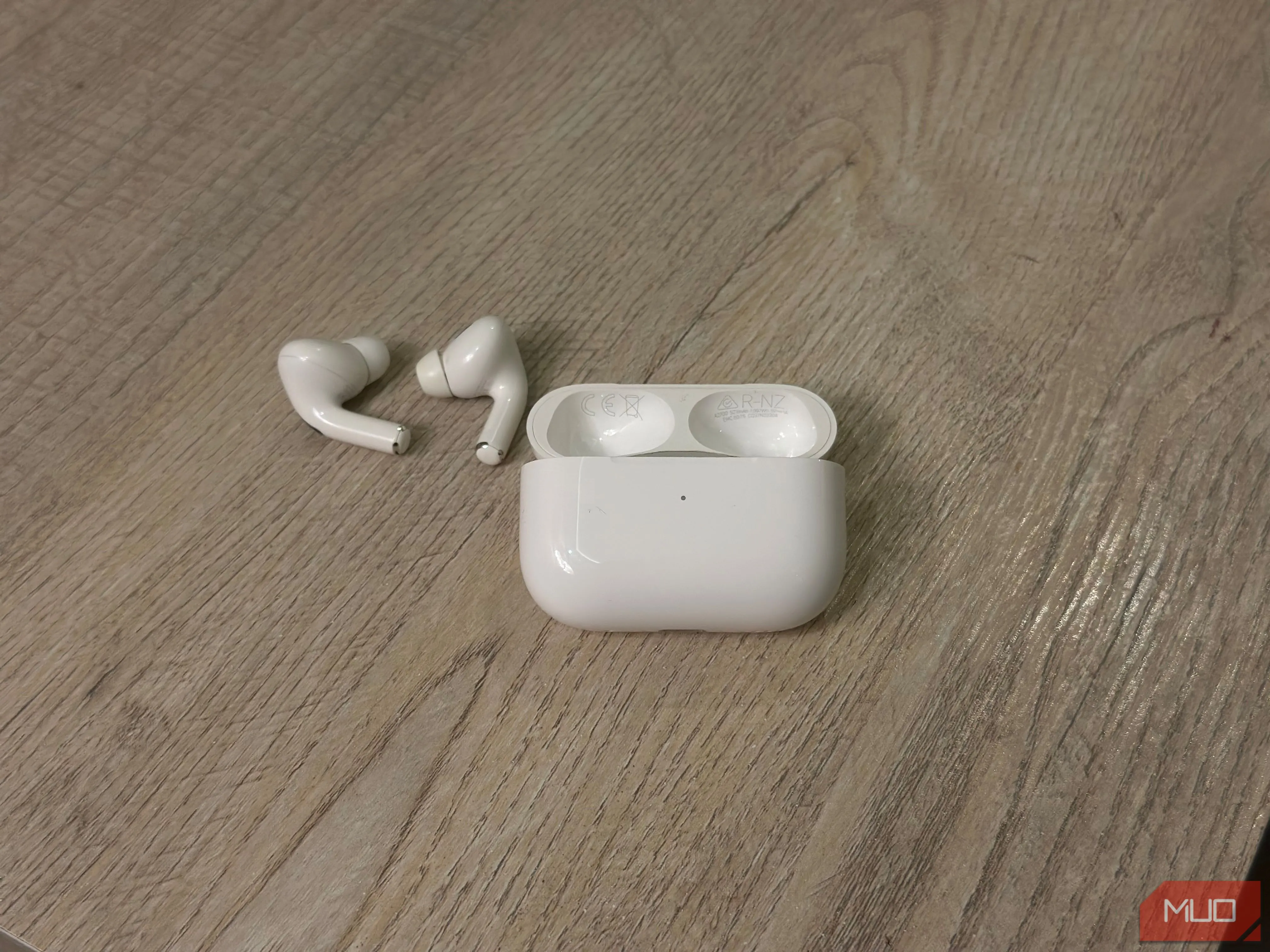 Hộp sạc AirPods màu trắng mở nắp, bên trong có hai chiếc tai nghe và số kiểu máy cùng số serial được in ở mặt trong nắp hộp sạc