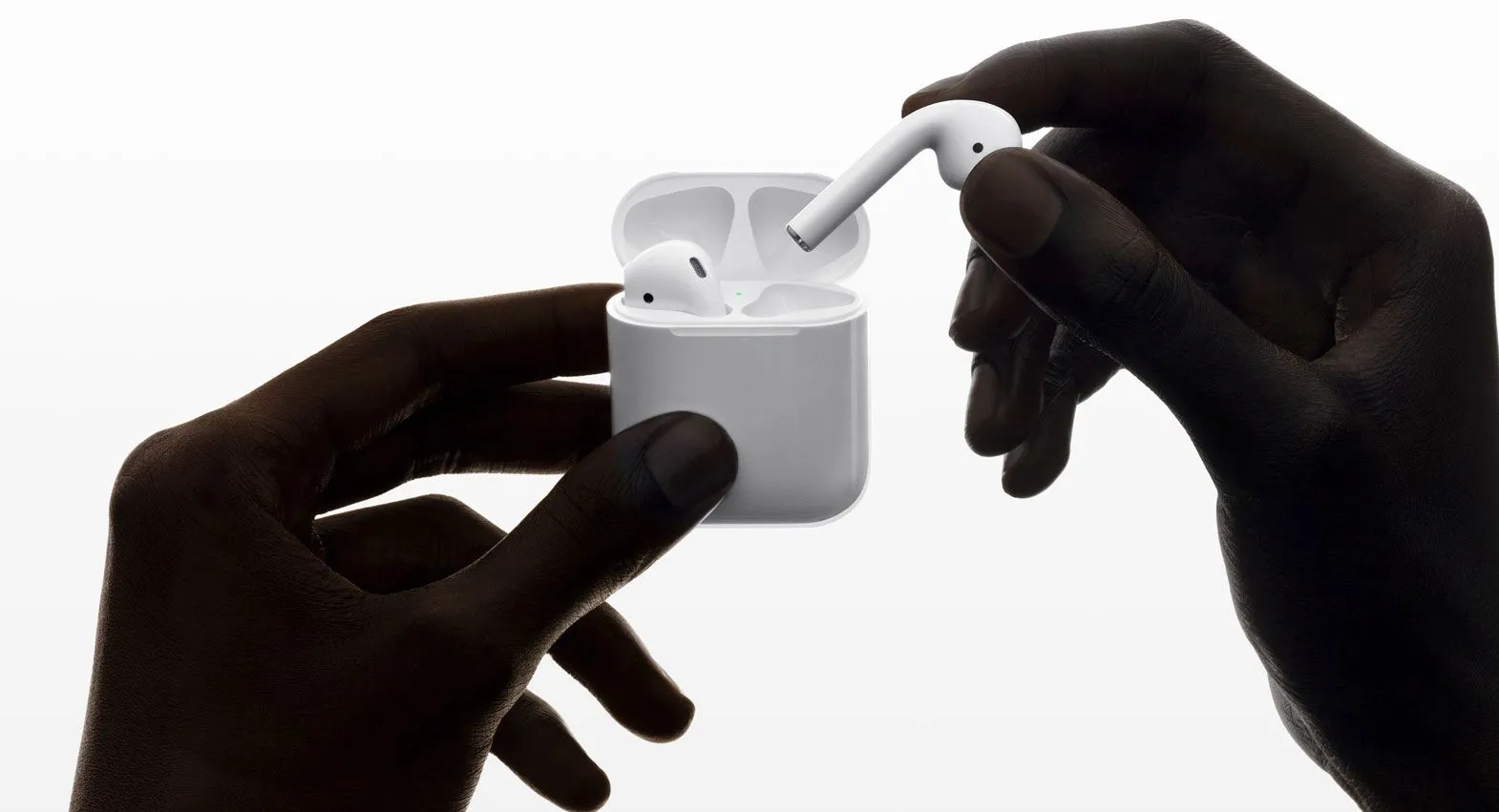Hộp sạc AirPods thế hệ thứ hai màu trắng với đèn trạng thái nằm ở mặt trước, thể hiện thiết kế bo tròn đặc trưng của các đời AirPods đầu