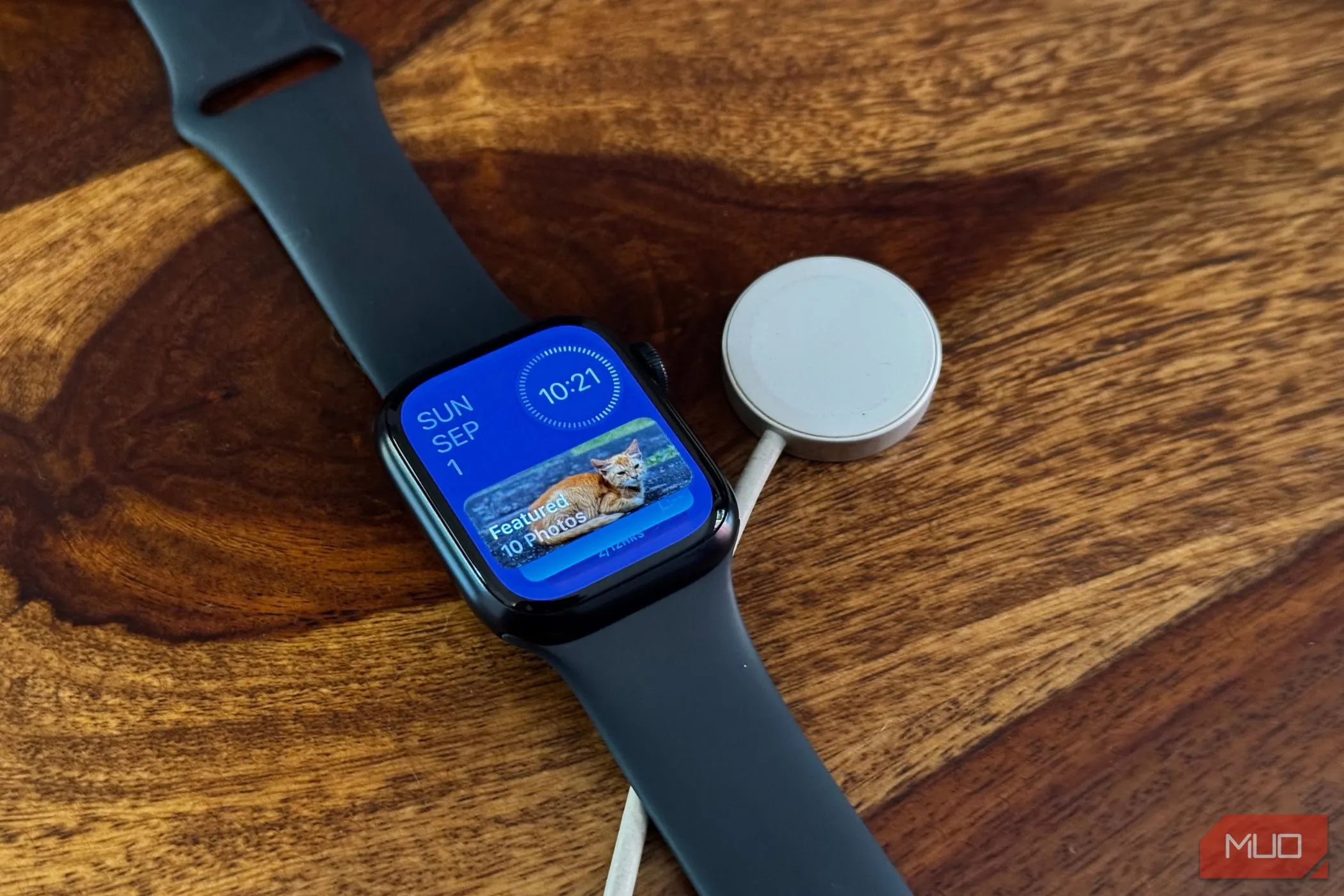 Màn hình Apple Watch hiển thị chế độ xem tiện ích cùng với đế sạc từ tính.