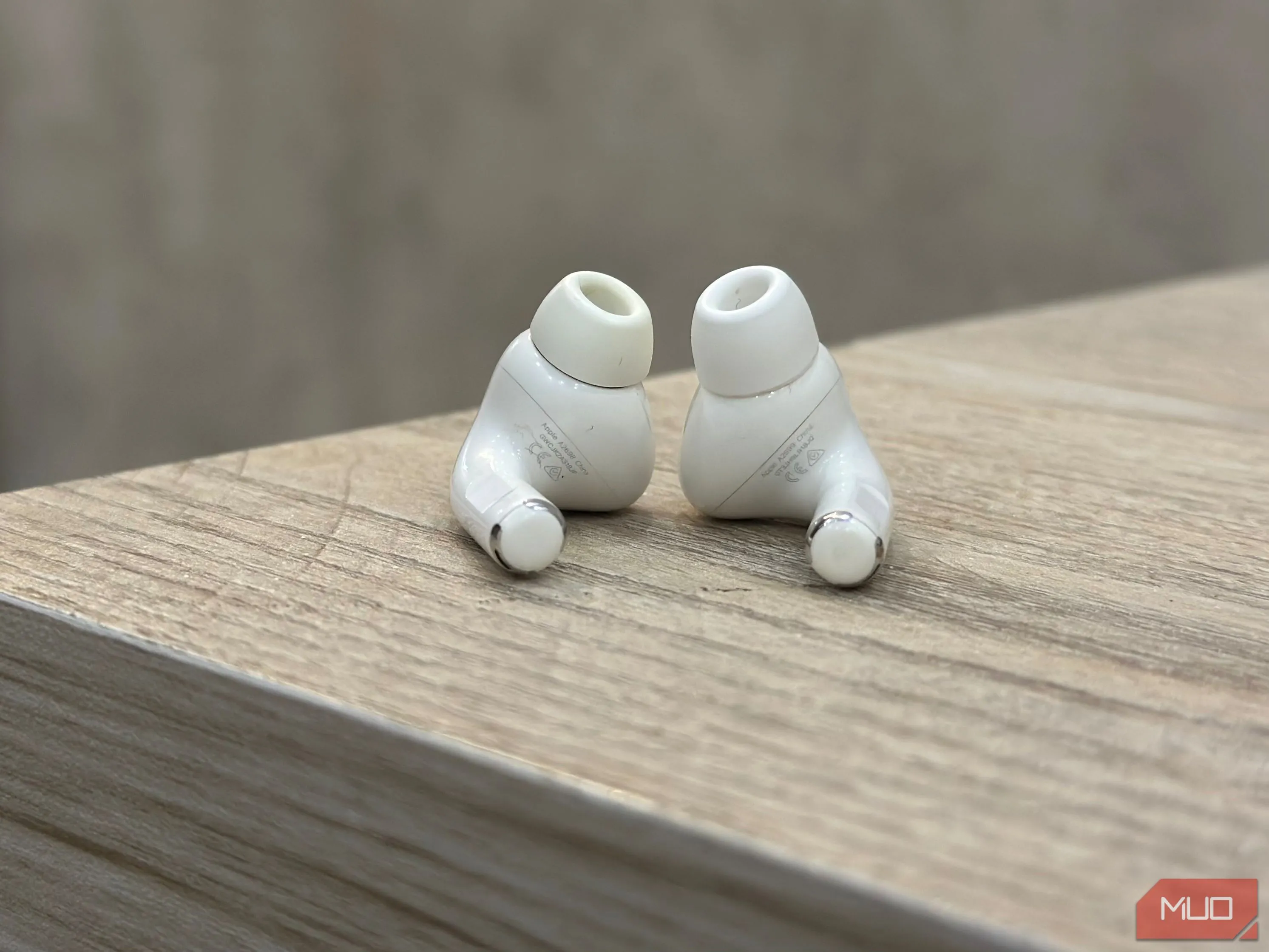 Mặt dưới của tai nghe AirPods Pro 2 với các chân sạc kim loại và số kiểu máy (model number) được in rõ ràng, thường bắt đầu bằng chữ 'A'