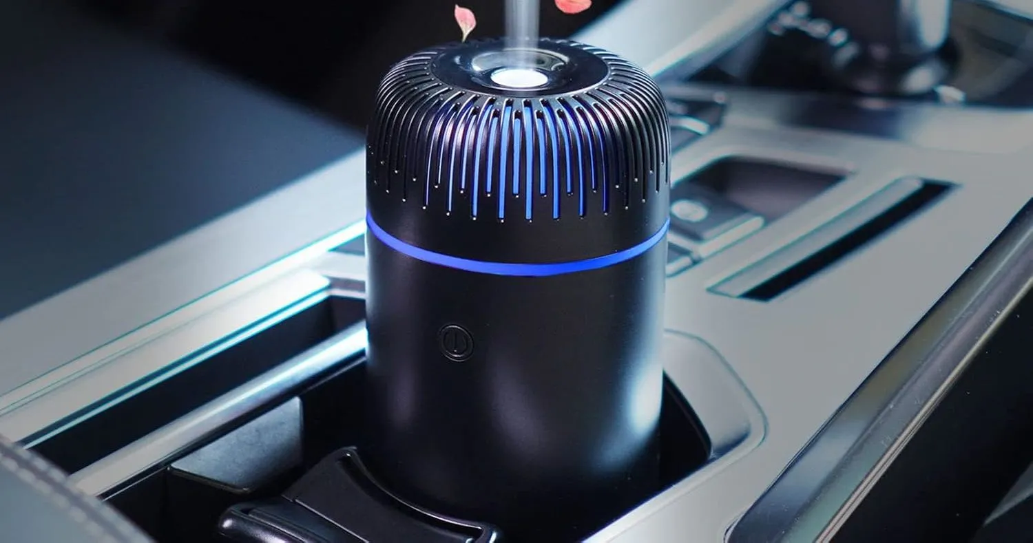 Máy tạo ẩm ô tô hình trụ nhỏ màu đen đặt trong hộc đựng cốc của xe
