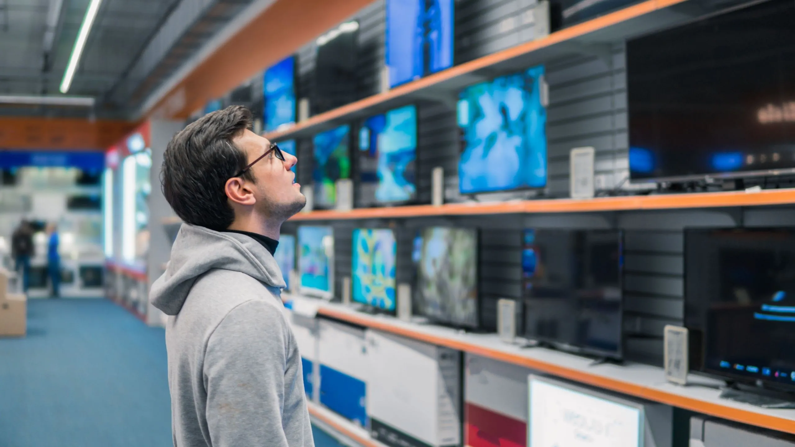 Người đàn ông đang xem kệ TV thông minh trong cửa hàng