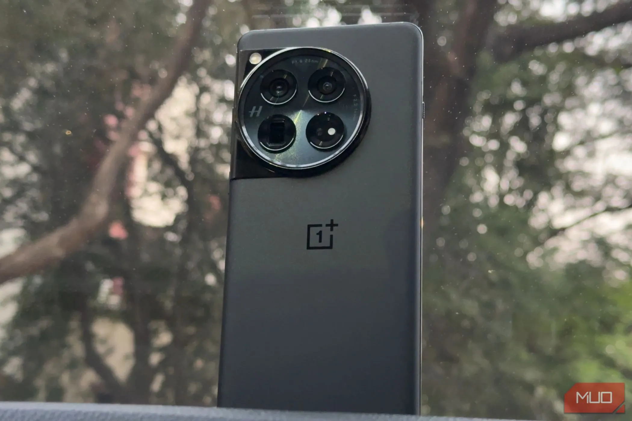 OnePlus 12 màu đen với thiết kế mặt lưng sang trọng đặt trên taplo ô tô