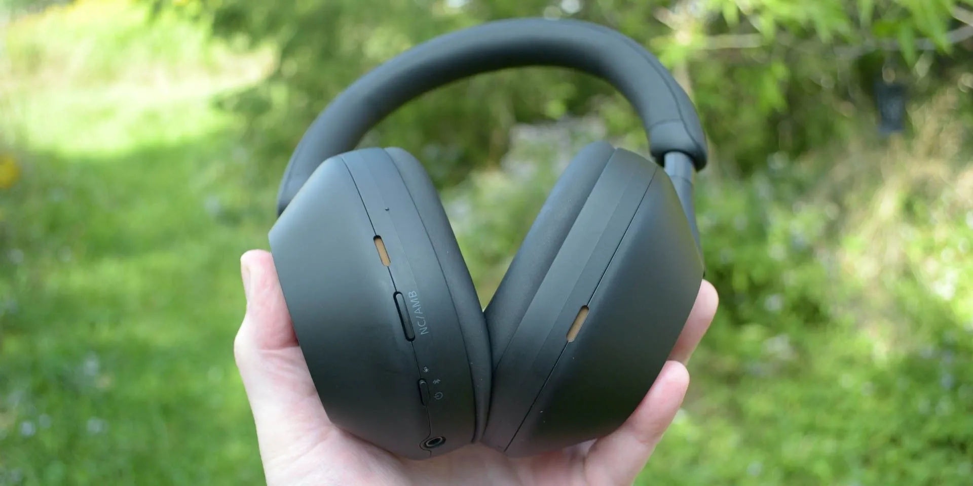 Tai nghe không dây chống ồn Sony WH-1000XM5 màu đen được cầm trên tay.